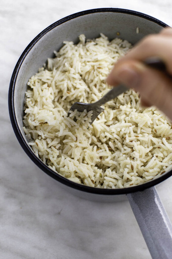 Fluffing up coconut rice with a fork