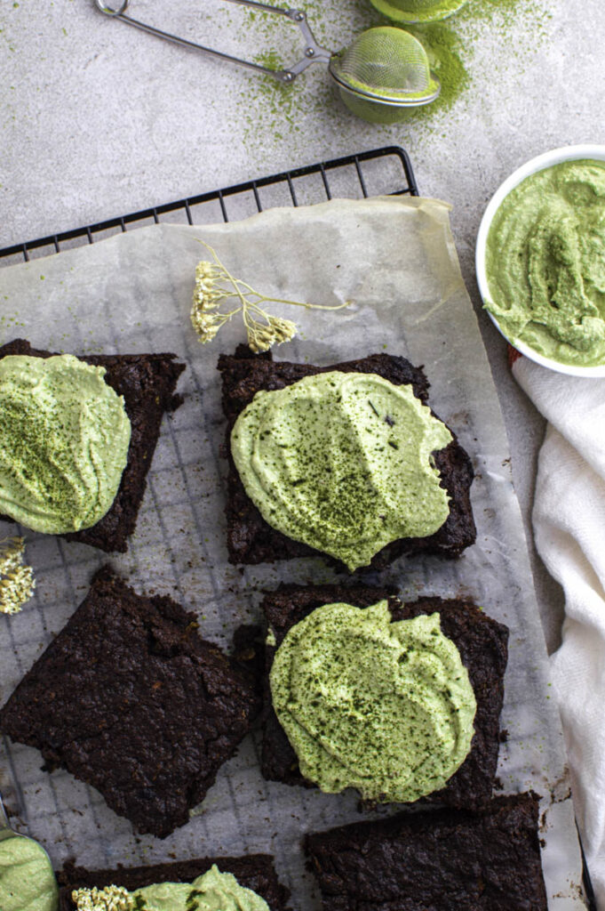Zucchini brownies topped with matcha frosting and laid on a cooling rack
