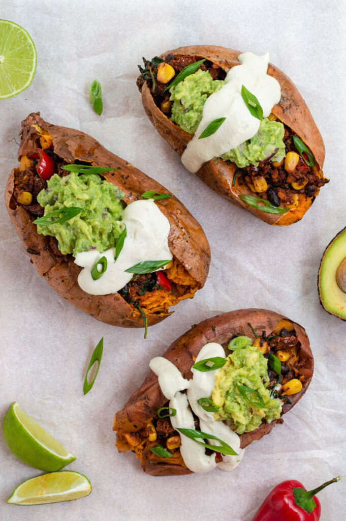 three stuffed sweet potatoes, placed on parchment paper and served for a dairy-free dinner