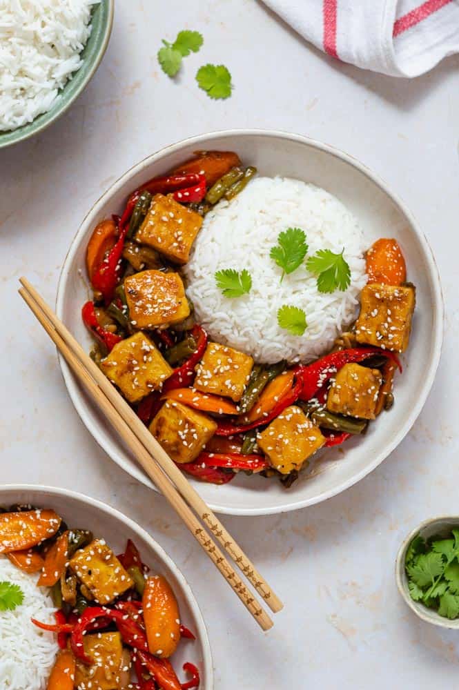 Teriyaki stir fry, served in a bowl with cooked rice on the side