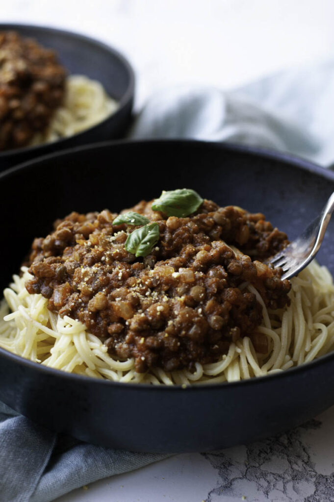 Vegan lentil Bolognese sauce served on top of cooked pasta, served for dinner