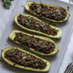 Zucchini boats arranged in a plate, topped with chopped parsley