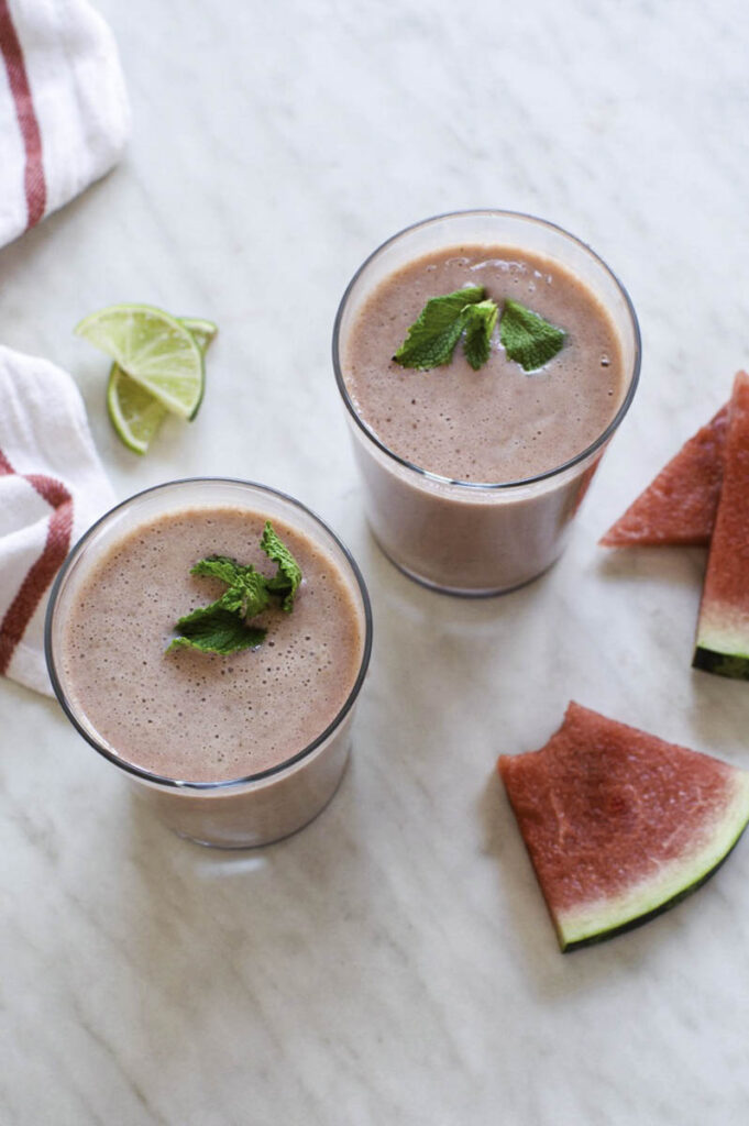 Glasses filled with watermelon smoothie, topped with mint leaves