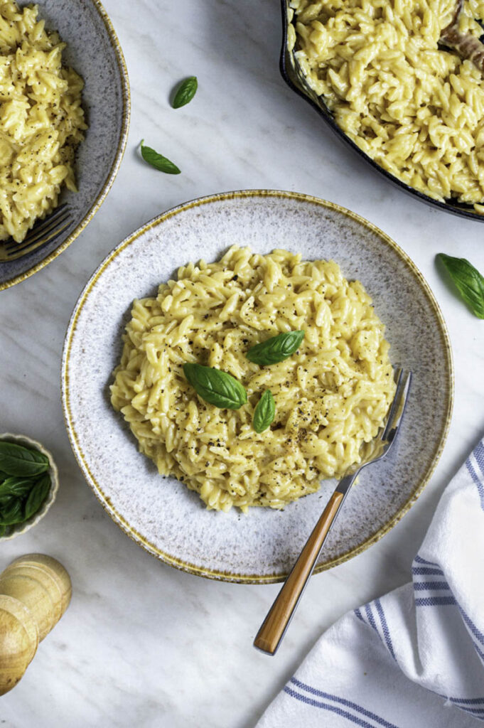 A blue bowl filled with orzo mac and cheese.