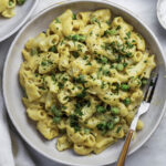 Vegan mac and cheese without cashews served on a plate, with a fork placed on the right side.