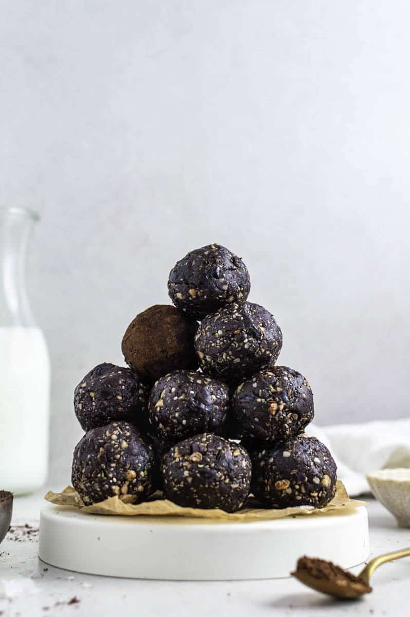 Brownie energy bites stacked on a white plate.