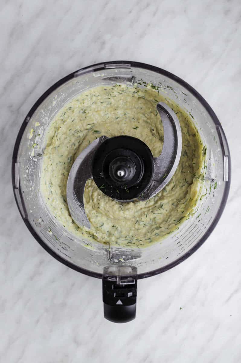 Lemon and dill hummus in a food processor bowl.