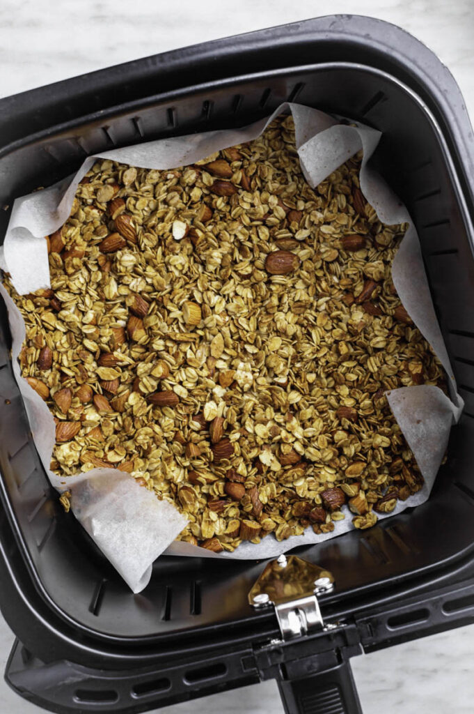 Air fryer basket filled with granola.