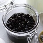 Cooked boba coated with brown sugar syrup in a glass jar.