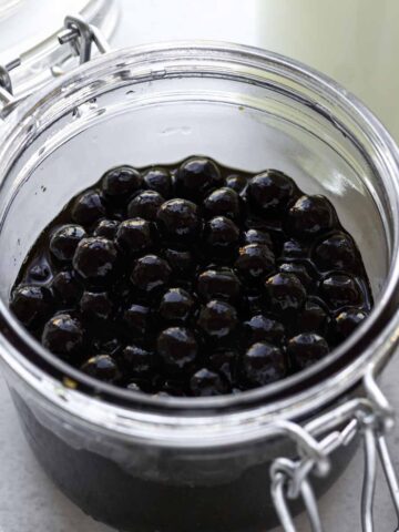 Cooked boba coated with brown sugar syrup in a glass jar.