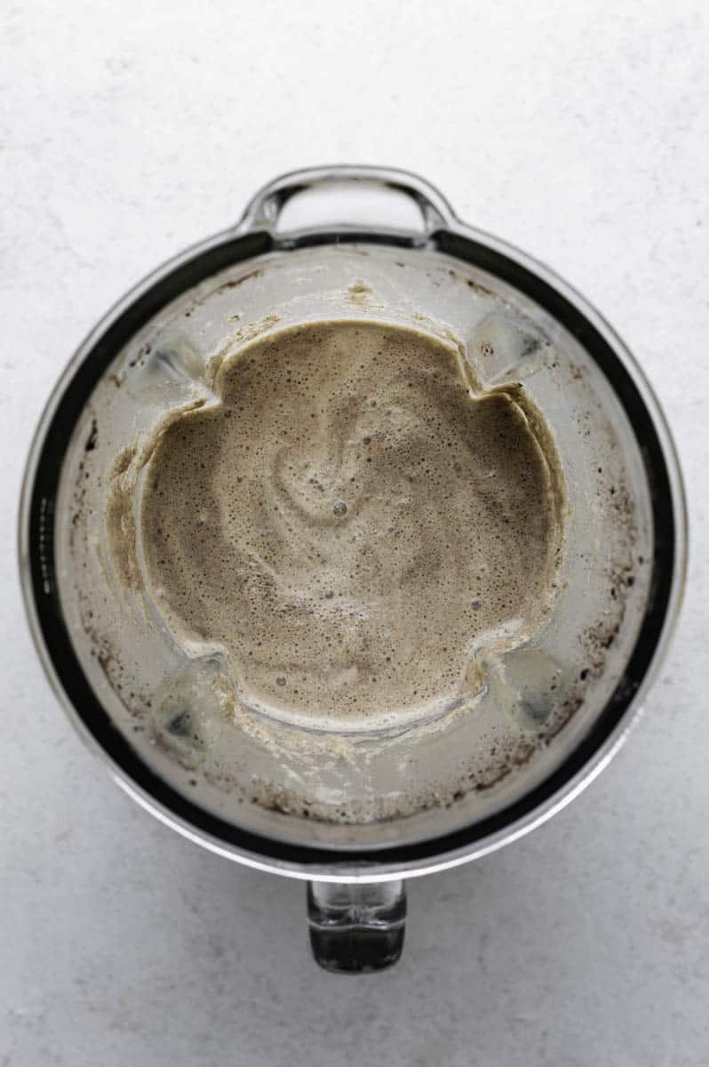 Oreo milk tea mixture in a blender jar.