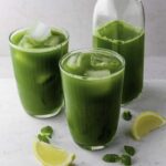 Two glassed filled with First Watch kale tonic recipe and ice cubes.