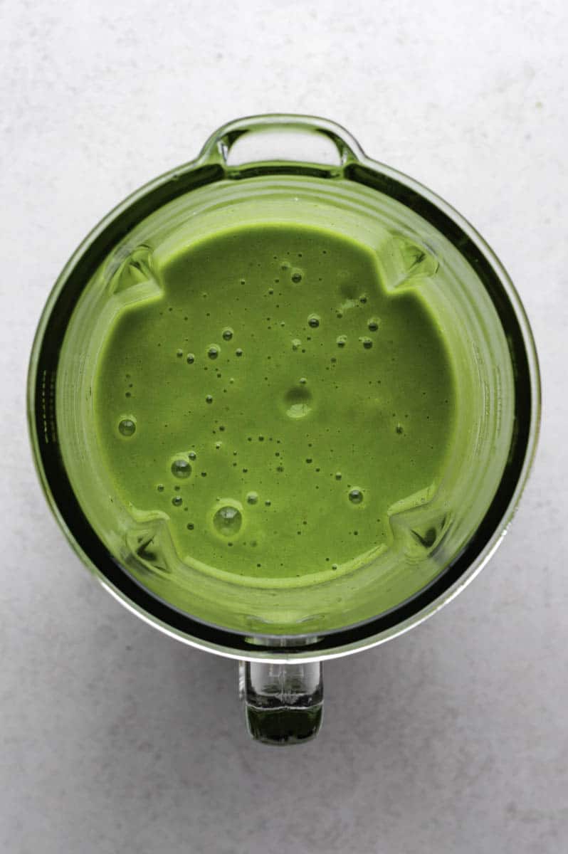 Blended green smoothie in a blender jar.