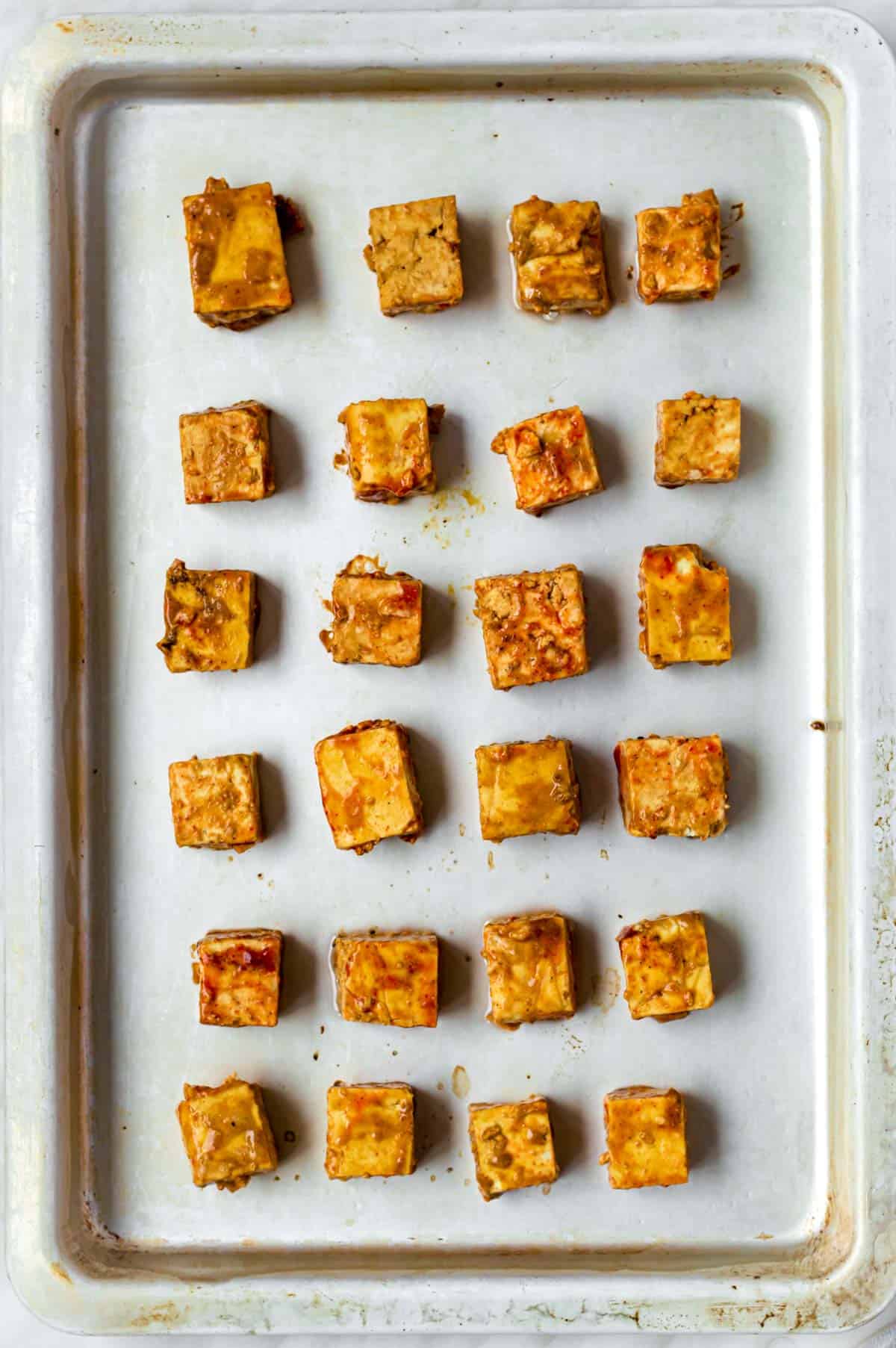 Tofu cubes on a baking tray, about to be baked.