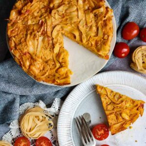 Vegan Pasta Frittata on a white plate with cherry tomatoes.