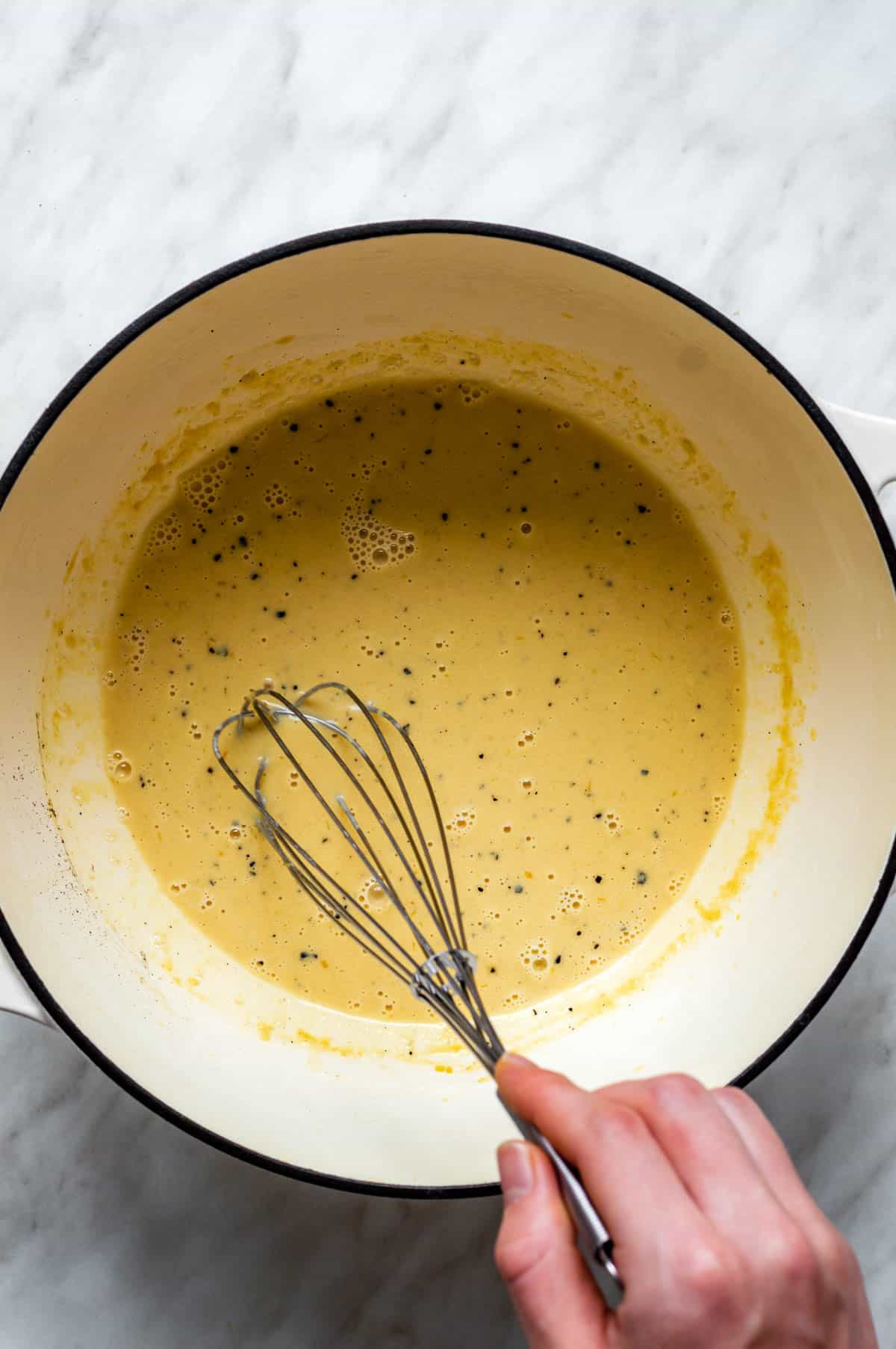 Stirring the creamy miso sauce with a whisk.