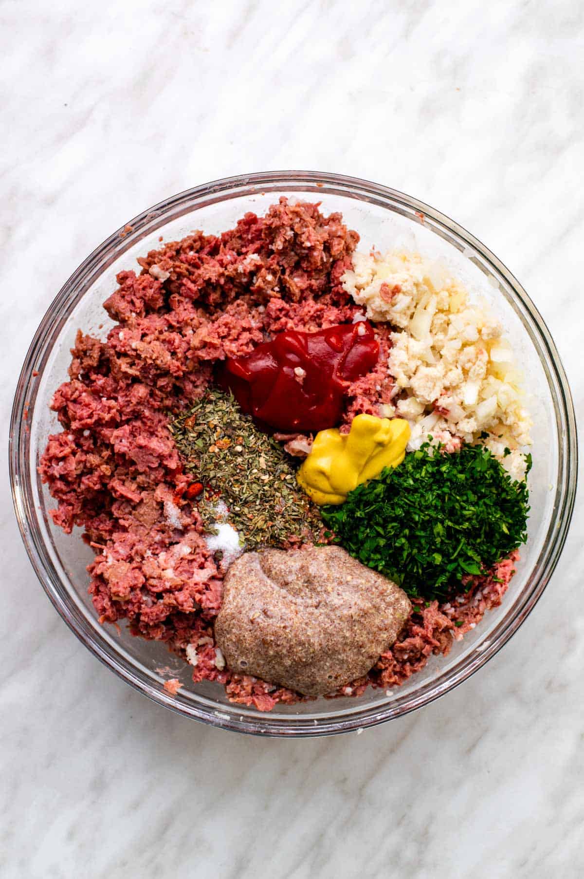 Ingredients for vegan meatloaf added to a large glass bowl.