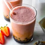 Boba tea smoothie served in a large glass with a boba straw in it.