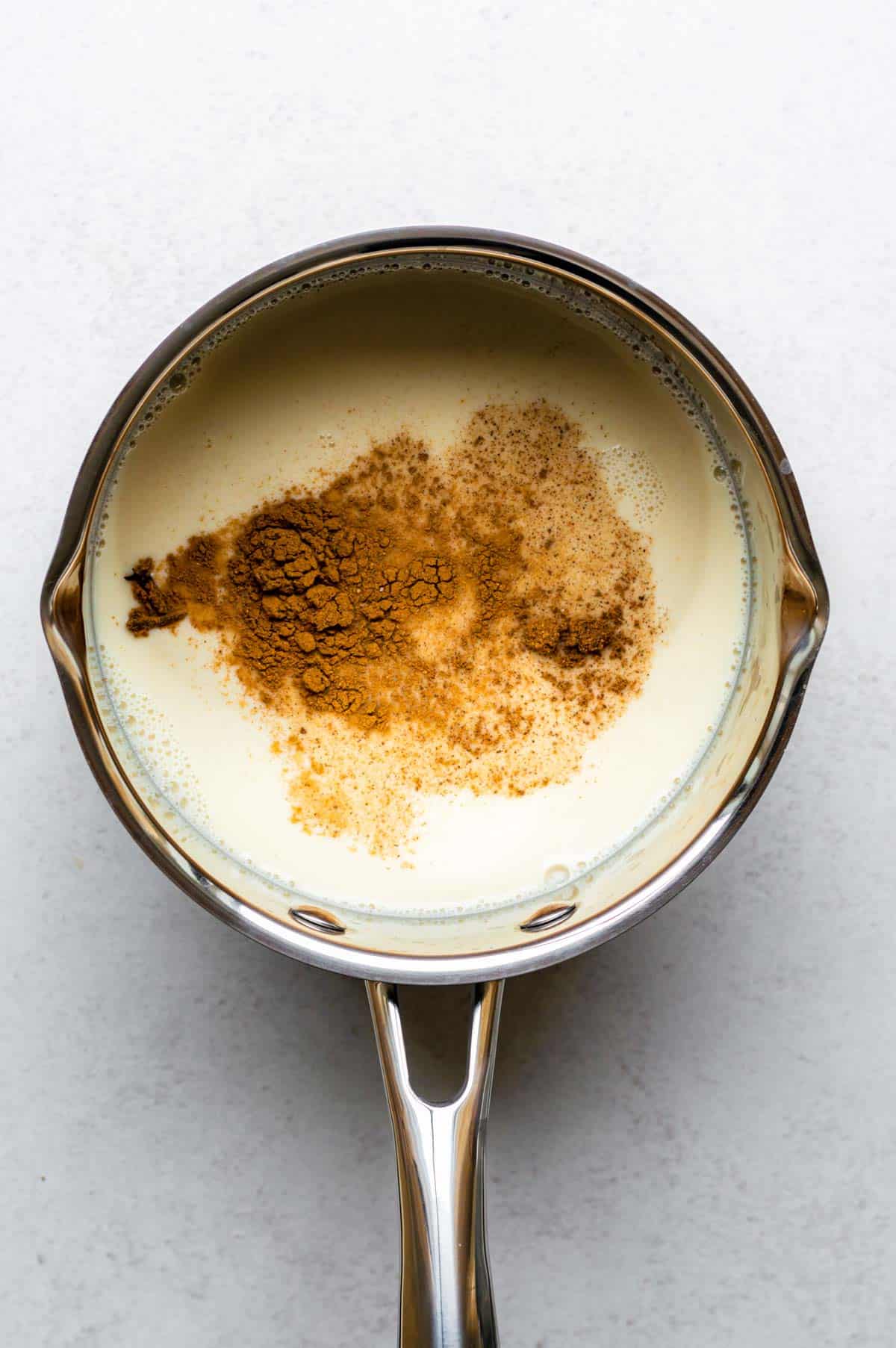 A saucepan filled with oat milk and spices.