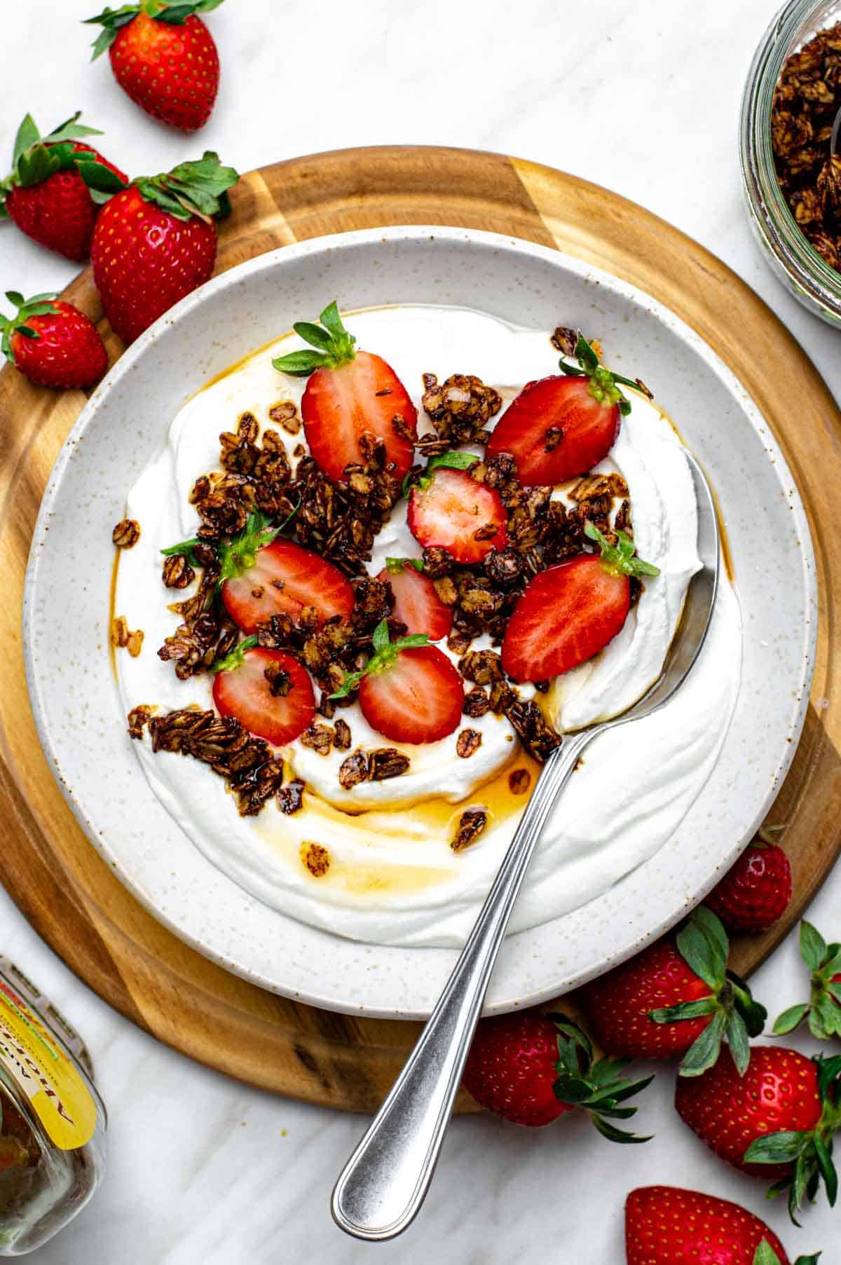 Blended cottage cheese served in a white bowl and topped with granola and strawberries.