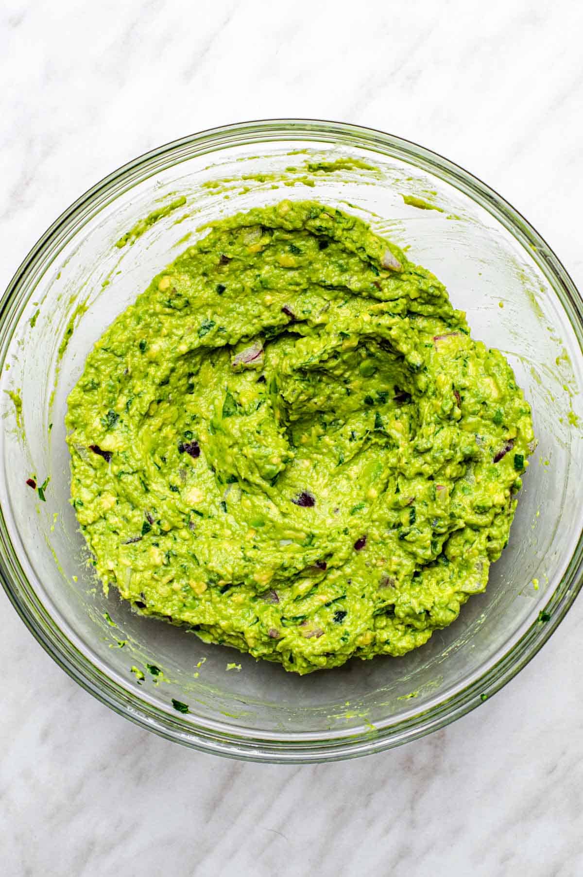 Guacamole without cilantro in a large mixing bowl.