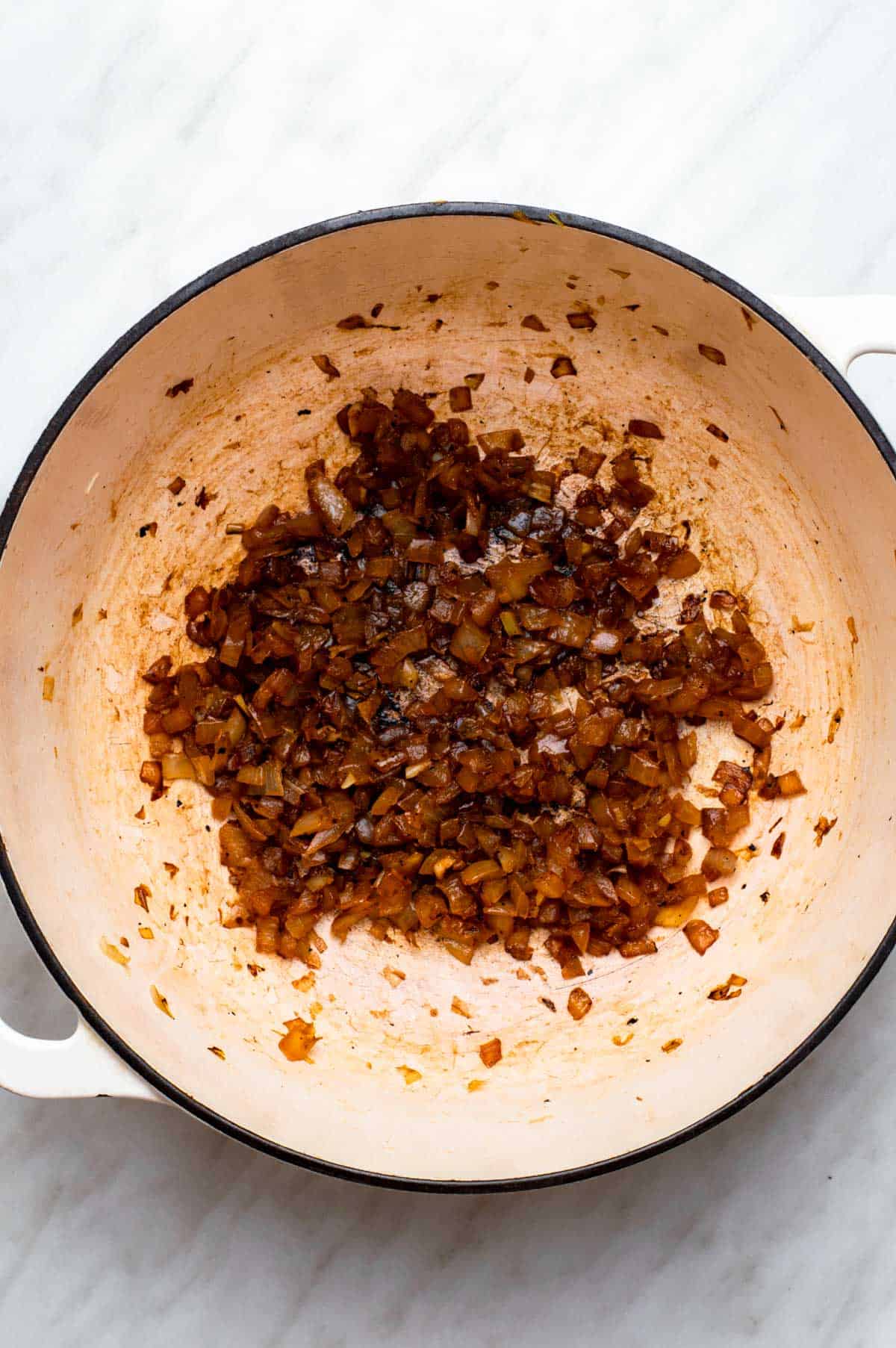 Caramelized onion in a white Dutch oven.