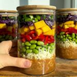 Peanut noodle salad jars on a wooden cutting board.