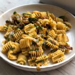 Caramelized onion pasta serve in a beige plate.