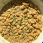 Cacio e Pepe butter beans in a white Dutch oven.