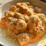 Tofu gnocchi served on a white plate topped with vegan parmesan.