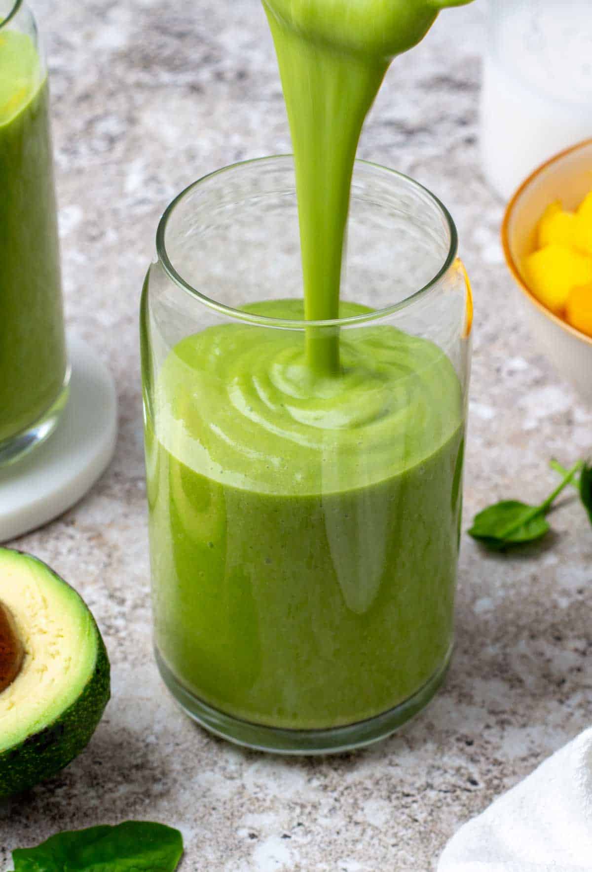 Pouring a green smoothie into a glass. 