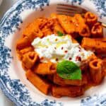 Gigi Hadid pasta without vodka in a bowl garnished with basil and cream.