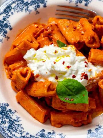 Gigi Hadid pasta without vodka in a bowl garnished with basil and cream.