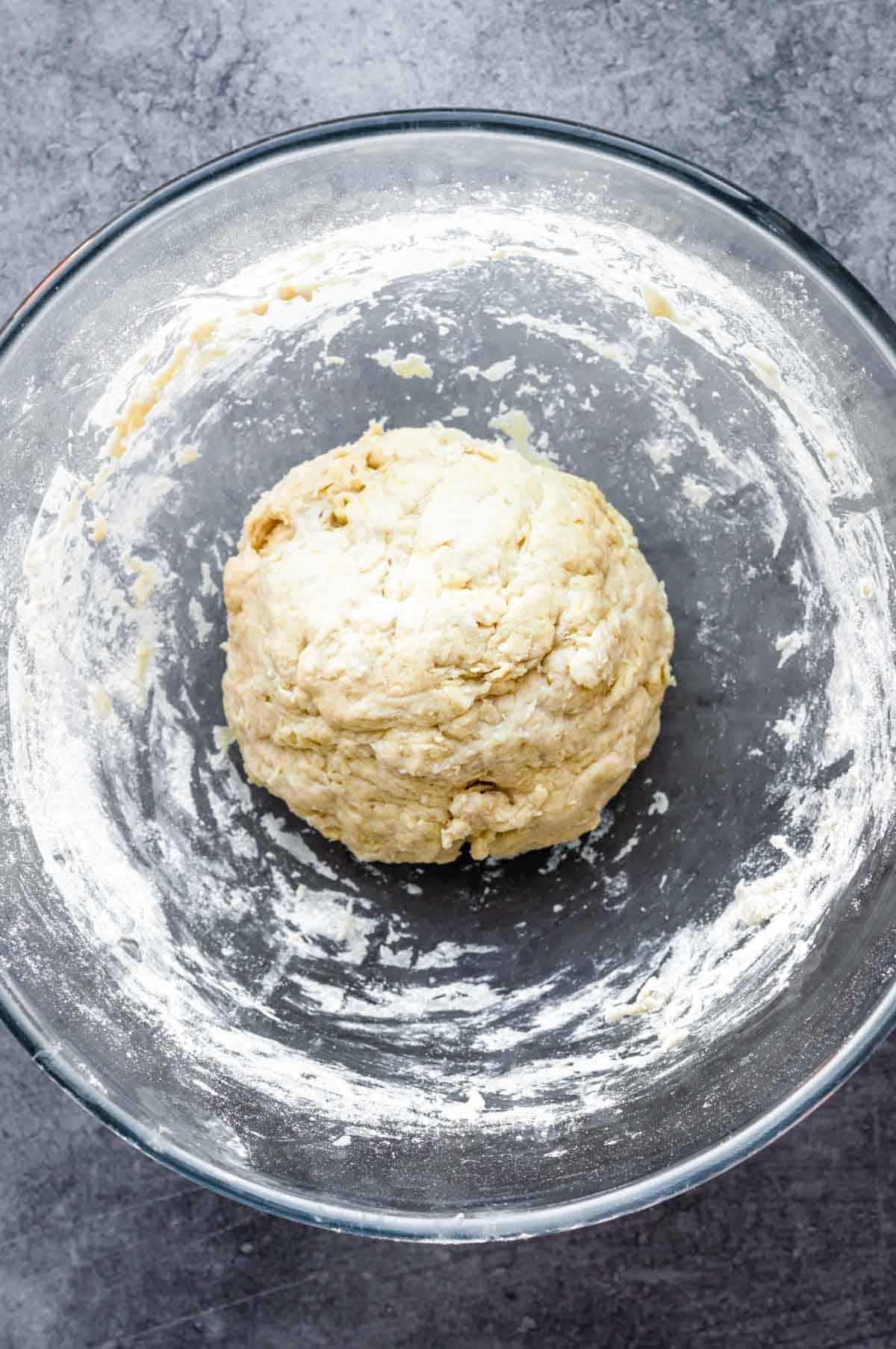 Naan dough in a glass bowl before kneading.