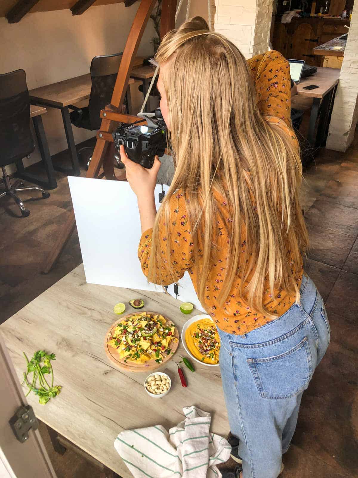 Petra, founder of Sunglow Kitchen, taking photos of a recipe using her digital camera.